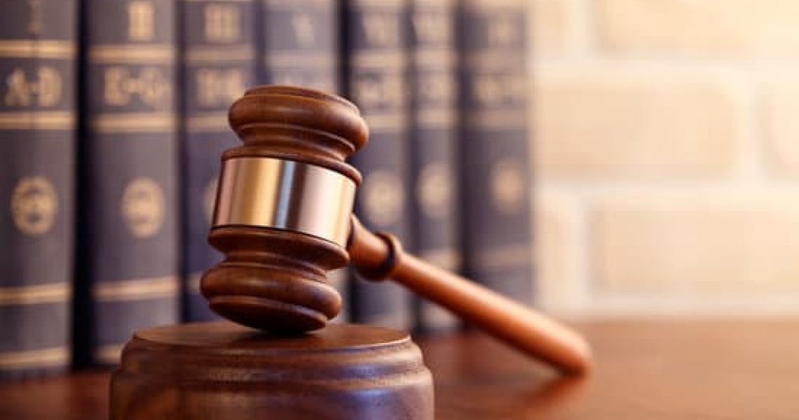 Gavel leaning against a row law books